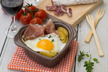 Spanish traditional dish fried eggs with serrano ham and potatoe