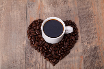 Symbol of Love, coffee in the coffee beans on Wood background