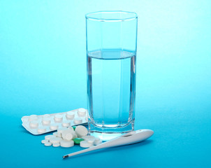 Tablets, glass with water and the thermometer