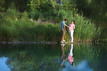 Fototapeta na wymiar Pregnant couple by the lake