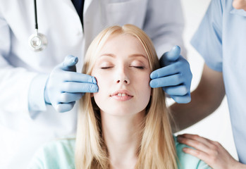 Naklejka premium plastic surgeon and nurse with patient