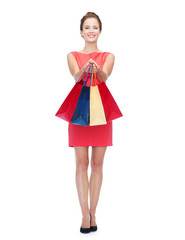 smiling elegant woman in dress with shopping bags