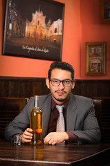 man in suit with bottle and alcohol shot