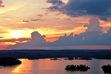 Naklejka na ściany i meble Thunder clouds above lake at sunset