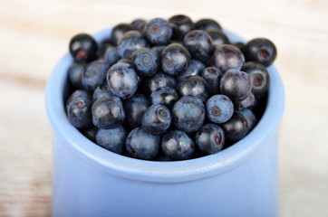 Blueberry in cup on vintage wooden background