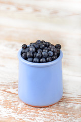 Blueberry in cup on vintage wooden background