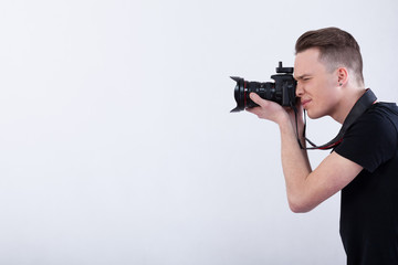 Young photographer on isolated white background