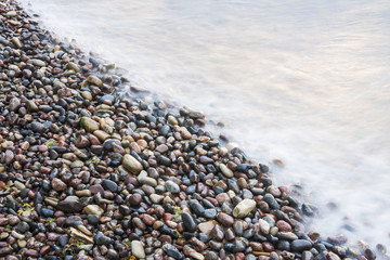 Sea waves on small rocks at seashore