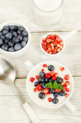 oatmeal with blueberries and strawberries in the white bowl