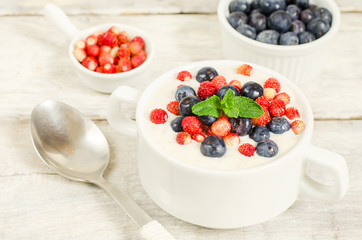 oatmeal with blueberries and strawberries in the white bowl