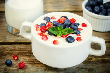 oatmeal with blueberries and strawberries in the white bowl