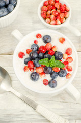 oatmeal with blueberries and strawberries in the white bowl