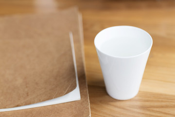 Workspace with cup, notebook on wooden table