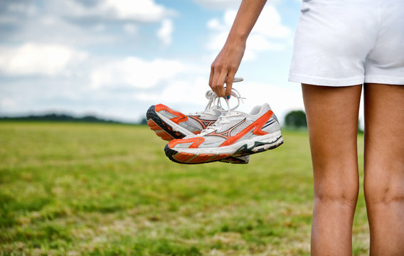 Young girl in shorts holding her sneakers - Powered by Adobe