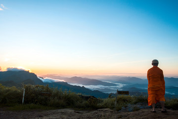 Fototapeta na wymiar Monk views sunrise scene at Phu chi fa in Chiangrai,Thailand