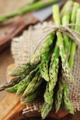 Bundle of fresh green asparagus on a wooden cutting board