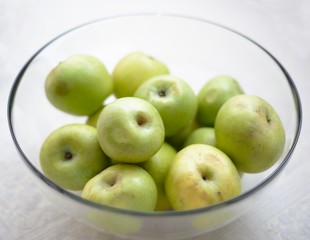 Glass bowl filled with green apples