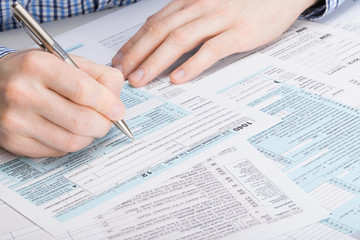 Obraz premium US 1040 Tax Form - male filling out tax form