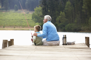 Senior man fishing with grandson