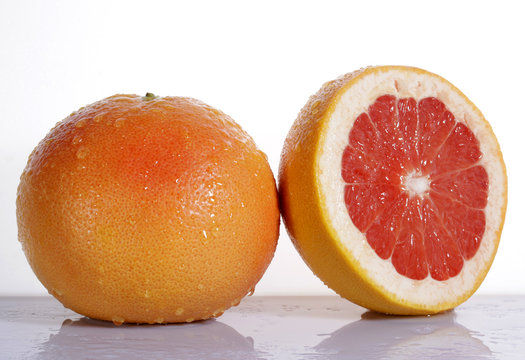 Grapefruit with half on white background