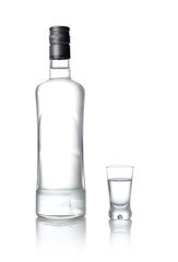 Bottle and glass of vodka standing isolated on white