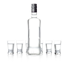 Bottle and glasses of vodka standing isolated on white