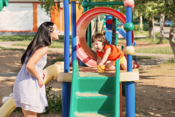 Fototapeta na wymiar Happy family on playground in summer