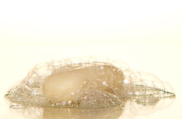Piece of toilet soap and soapsuds with air bubbles