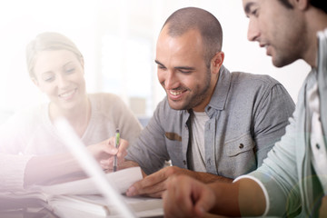 Fototapeta premium Young people in college studying together in library