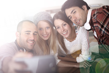 Group of friends taking picture of themselves with smartphone