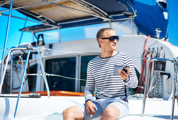 Fototapeta na wymiar Young and handsome man on a sailing boat