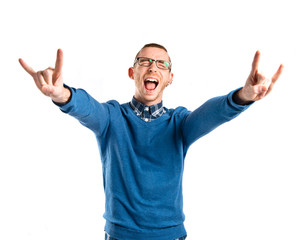 Young man doing the horn gesture over white background