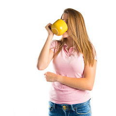 Blonde girl drinking coffee over white background