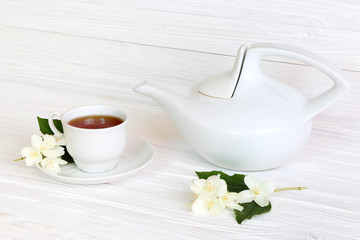Cup with jasmine tea on a light wooden background