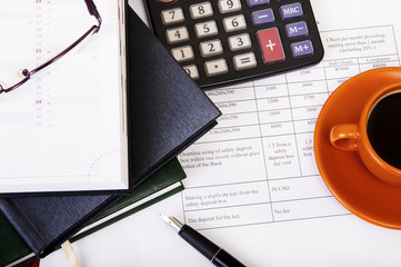 Calculator,pen, notebook and business reports. Coffee Break