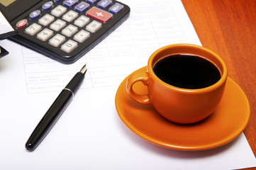 Calculator,pen, notebook and business reports. Coffee Break