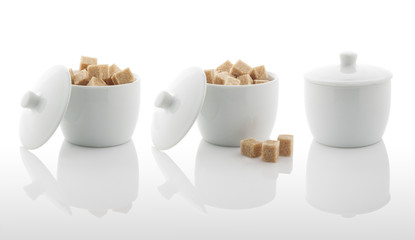 White sugar bowl and brown sugar cubes