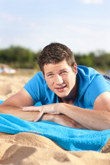 Young man lying on the beach