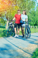 Caucasian Couple Walking With Bicycles in Nature Surroundings