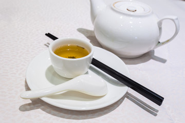 White Cup of tea with teapot on the table