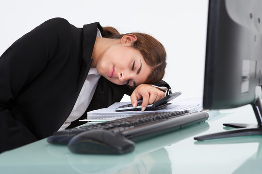 Stressed Businesswoman Leaning At Desk
