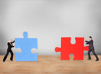 Business People Joining Puzzle Pieces On Desk