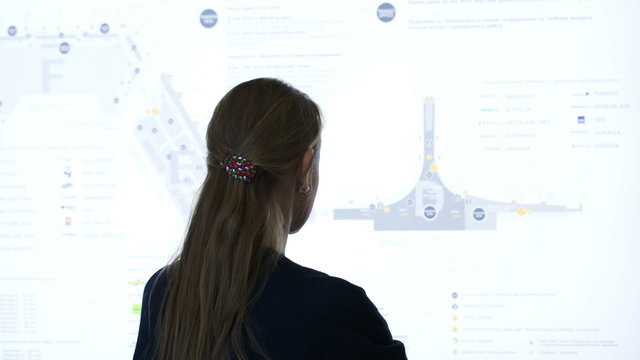 Woman exploring schematic map at the airport or trade cemter