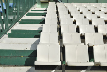 Fototapeta premium Rows of broken and stained white chairs in an outdoor auditorium