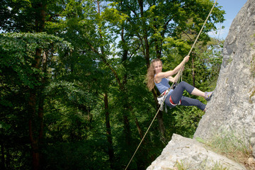 young woman climbing a rock wall