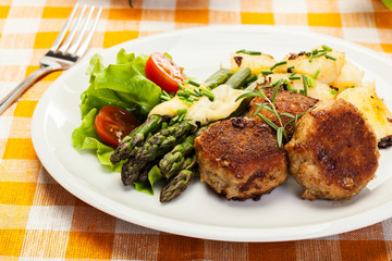 Meatballs served with boiled potatoes and asparagus