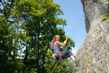 young woman climbing a rock wall