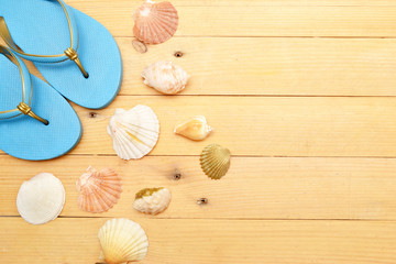 Beach slippers and shells on wood