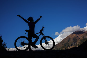 Girl cycling at the road in Himalaya