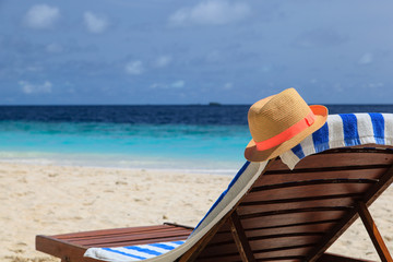 straw hat on a lounge chair at tropical beach